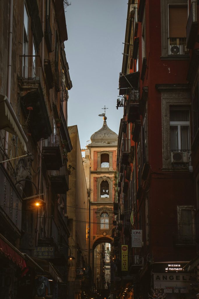 A tranquil alleyway view of historic architecture in Naples, Italy, at dusk.
